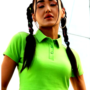 A young woman wearing a bright green cropped polo T-shirt with short sleeves, styled with playful braided hair and hoop earrings, posing confidently against an urban backdrop.