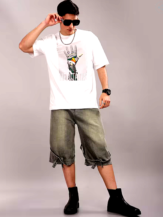  A male model wearing a white oversized T-shirt with a graphic print of a robotic hand and the word "MEDITATIVE," paired with baggy denim shorts and black boots.