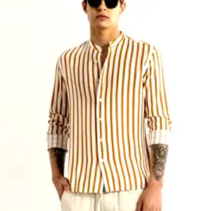 A male model wearing a mustard and white vertically striped full-sleeve shirt with a mandarin collar, paired with light-colored trousers and sunglasses.