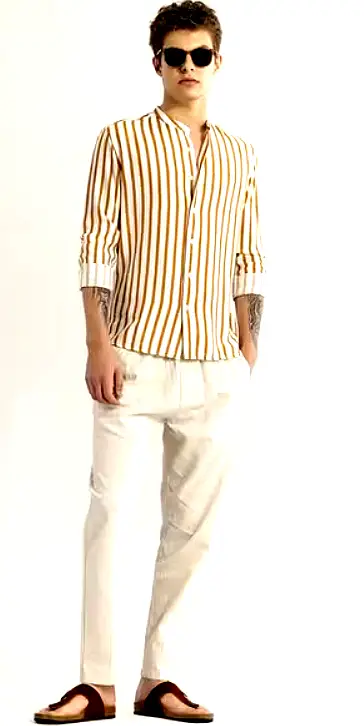 SNITCH 4 Full-body shot of a male model wearing a Snitch striped shirt with white linen trousers and brown sandals.