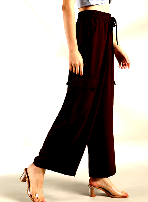 Side view of brown wide-leg cargo pants with large utility pockets and an elastic waistband.