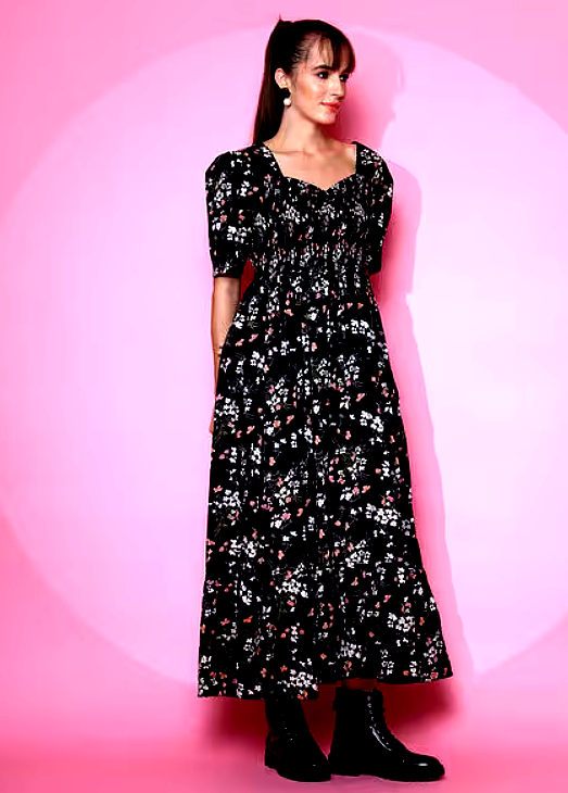 SHEETAL ASSOCIATES 3 Front view of a woman wearing a black floral smocked maxi dress with puffed sleeves.