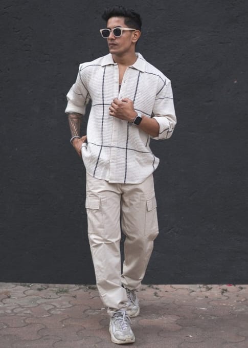 Person wearing a white grid-patterned shirt .