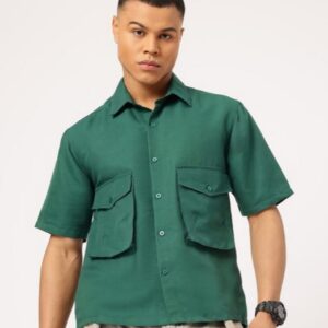 A person is modeling a green short-sleeve button-up shirt with two large flap pockets on the chest.