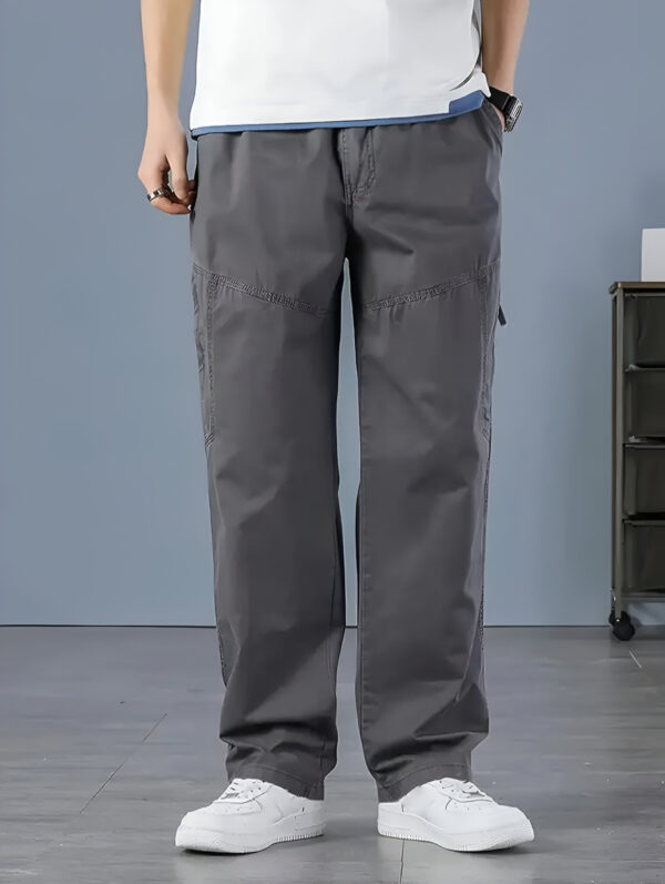 Person wearing dark gray cargo pants with visible stitching and white sneakers, standing in a relaxed pose.