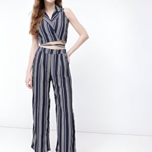 Woman wearing Dressberry navy blue and white striped two-piece co-ord set featuring a sleeveless wrap crop top and high-waisted wide-leg trousers, paired with white platform sandals.