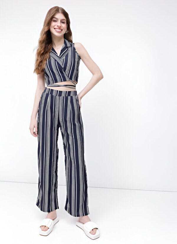 Woman wearing Dressberry navy blue and white striped two-piece co-ord set featuring a sleeveless wrap crop top and high-waisted wide-leg trousers, paired with white platform sandals.