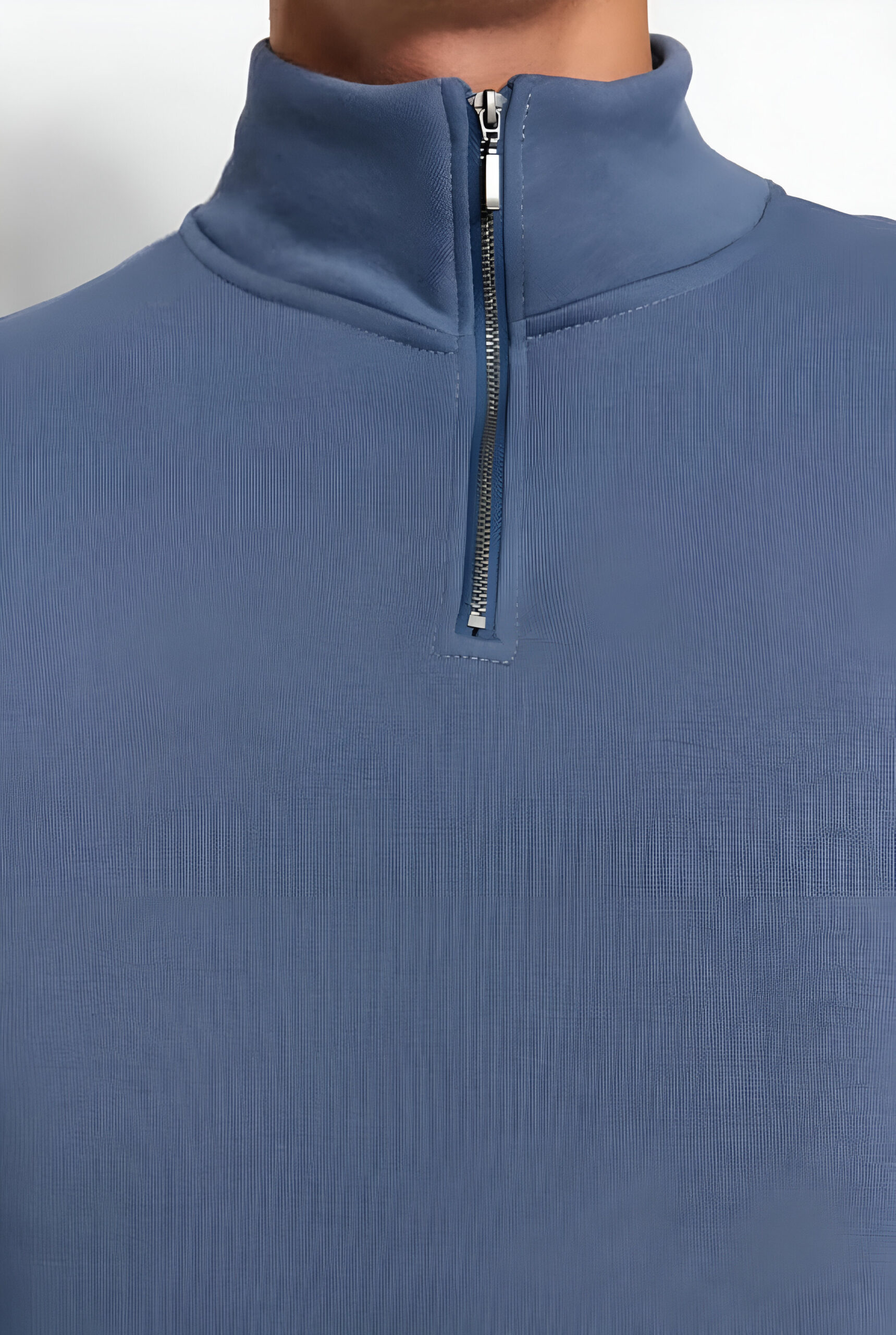 Close-up of the collar and zipper of a blue quarter-zip pullover with ribbed fabric and neat stitching.