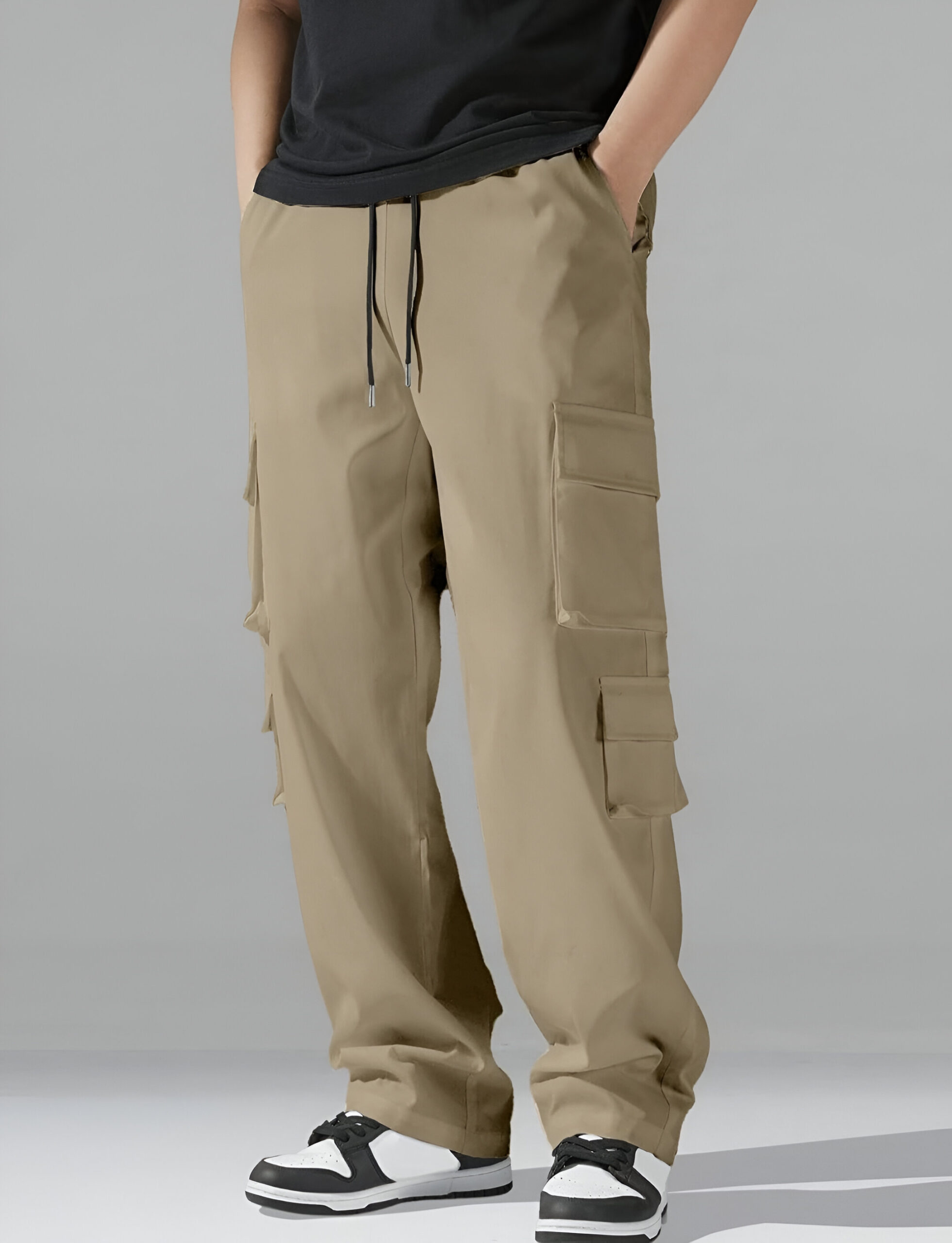 Men’s khaki cargo pants with a relaxed straight-leg fit, large side pockets, drawstring waist, and styled with black and white sneakers against a neutral background.