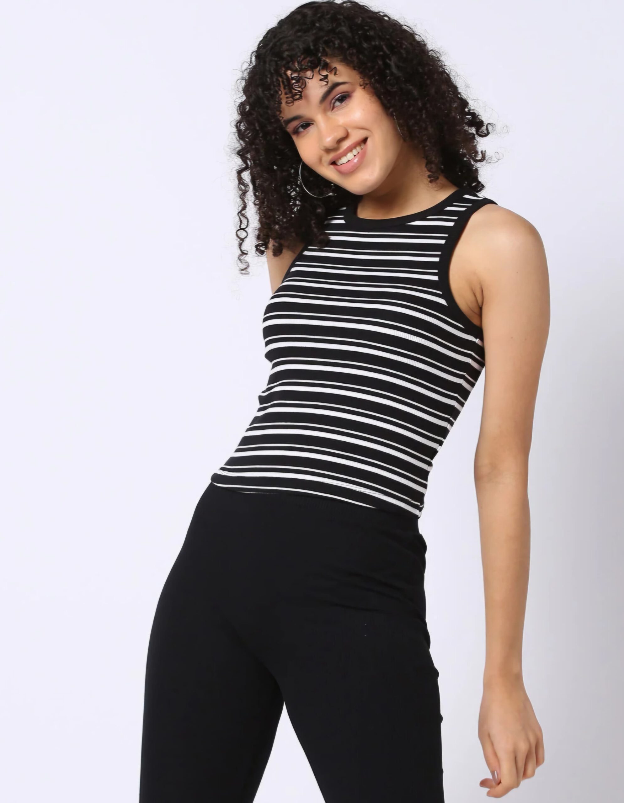 RIO BASIC 3 Woman in a black crop tees for women with white stripes, paired with black pants and accessorized with hoop earrings.