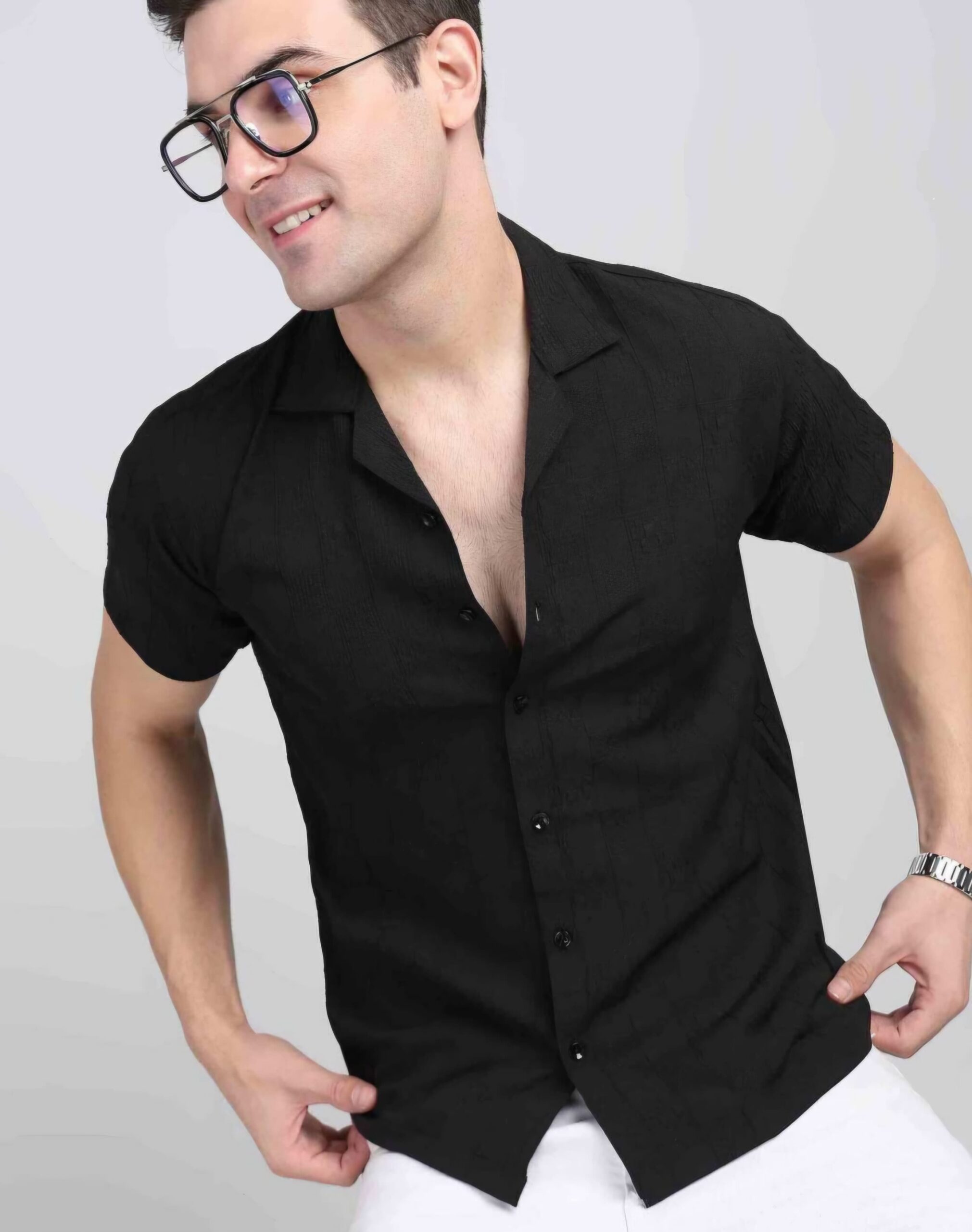 SILVERFLY 3 Man wearing men's casual black shirt , short-sleeve button-down shirt paired with white pants, accessorized with glasses and a watch, posing against a light background.