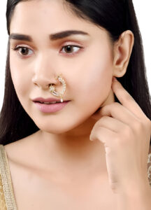 Saraf RS Jewellery (women) 4 Woman wearing an elegant crescent-shaped bridal nose ring with intricate stone detailing, showcasing traditional ethnic jewelry.