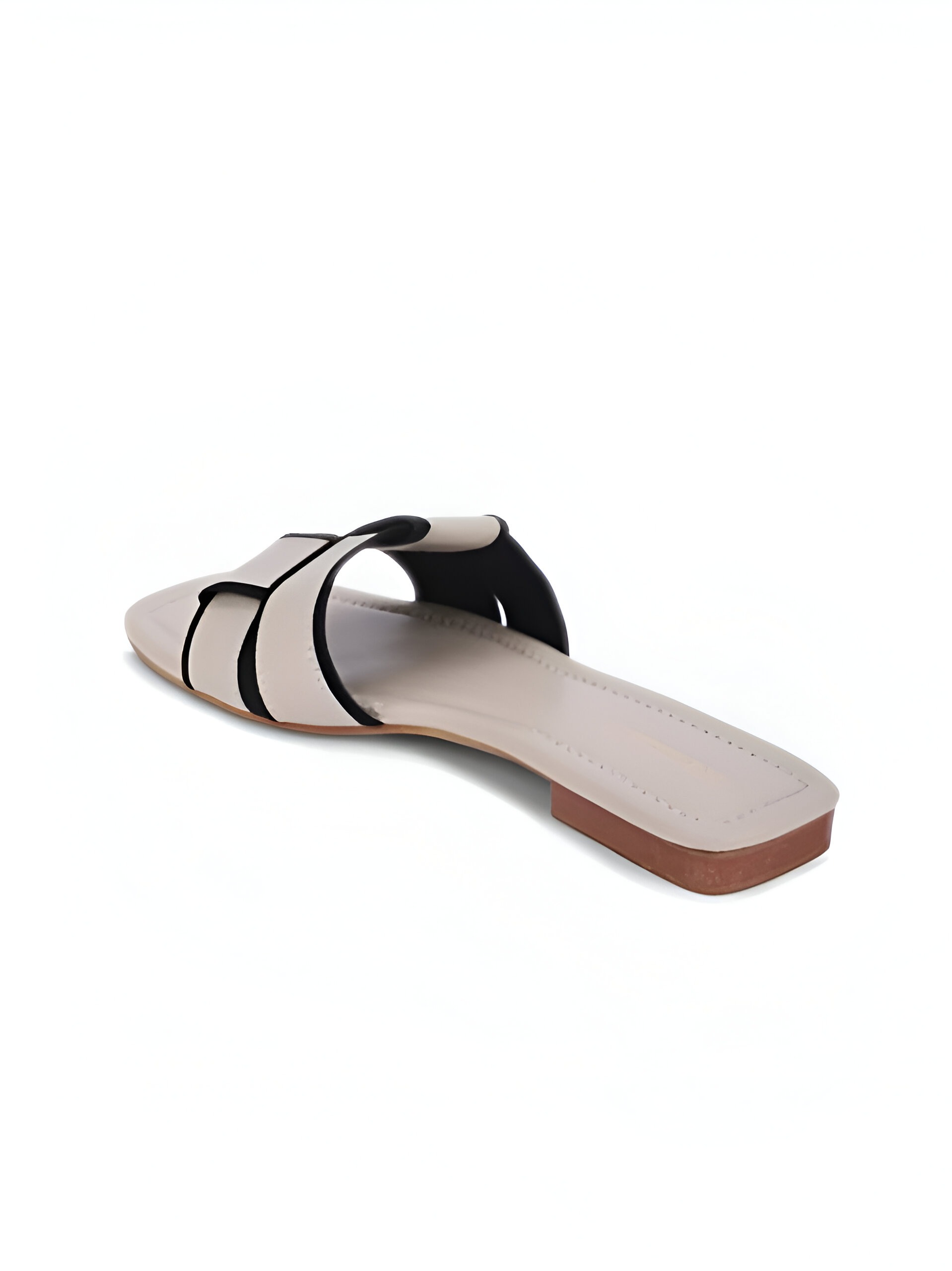 Dressberry (Women) 5 Side view of a beige slip-on sandal with black piping details, featuring a flat sole and wide crisscross straps against a white background.